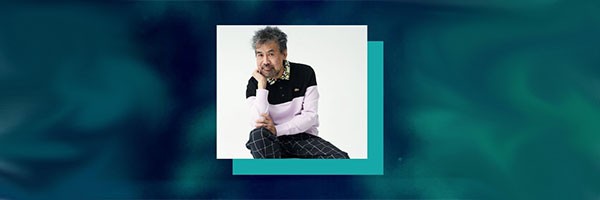 David Henry Hwang headshot on tie-dye blue background. 